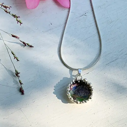 Haarlokje in een hanger met emaille