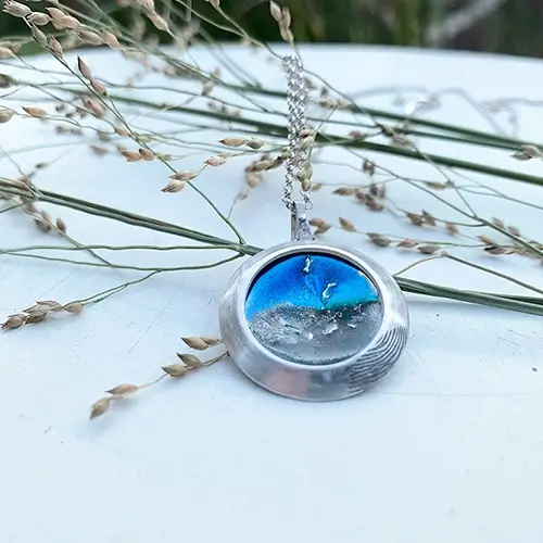 Een dreamscape hanger met emaille, as en een vingerafdruk