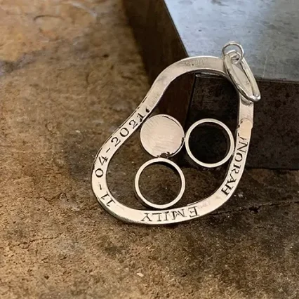 Een handgravure op de rand van een gedenksieraad